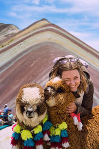 Portrait of smiling woman with mammals against mountains