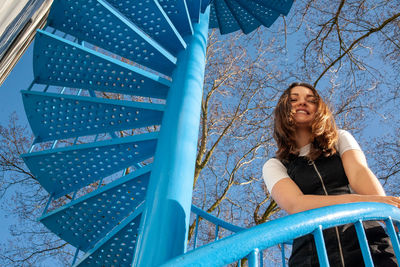 Portrait of a smiling young woman from low angle