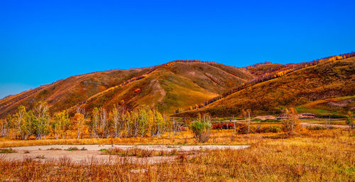 Scenic view of mountains against clear blue sky