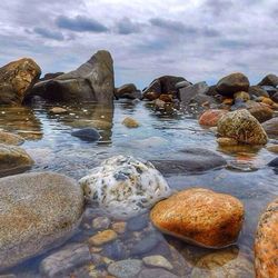 Scenic view of rock formations against cloudy sky