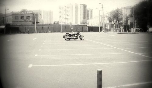 Man riding motorcycle on street against buildings in city