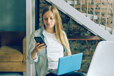 Young woman using mobile phone in office