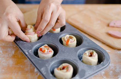 Cropped hands of woman preparing food in baking tray