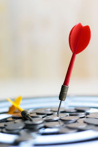 Close-up of darts and coins on dartboard