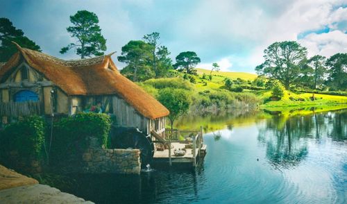 Houses by river against sky