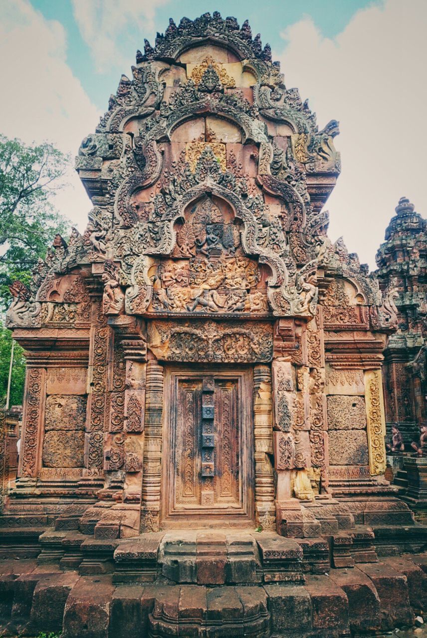 architecture, place of worship, built structure, spirituality, art, sky, low angle view, history, carving - craft product, temple - building, ornate, travel destinations, day, outdoors, facade, no people, the past, cloud - sky, carving, temple, tourism, ancient