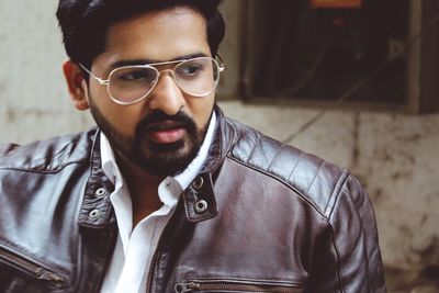 Close-up of thoughtful young man wearing brown leather jacket