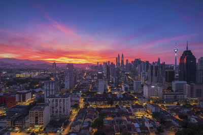 Aerial view of buildings in city during sunset