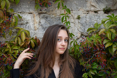 Portrait of young woman with leaves outdoors