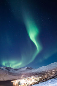 Aurora borealis over night village landscape photo