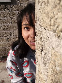 Portrait of young woman by wall