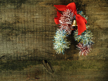 Bell with ribbons hanging on wooden wall