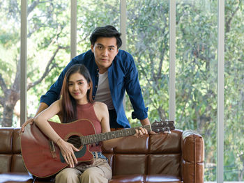 Portrait of a smiling young man playing guitar