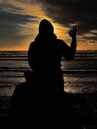 Silhouette of people at beach during sunset