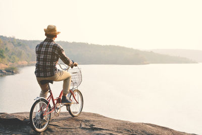 Man on bicycle on road against clear sky