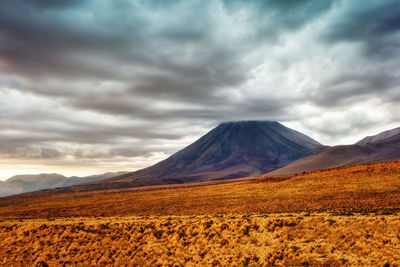 Scenic view of mountain range against cloudy sky