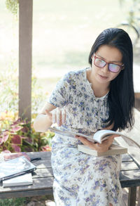 Woman reading book while sitting at park