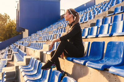 Woman sitting on chair in stadium