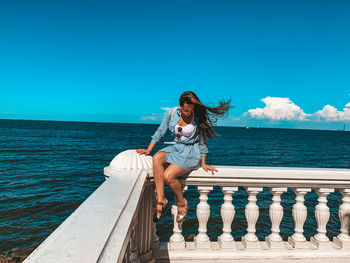 Full length of young woman against sea