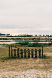 Fence on field against sky