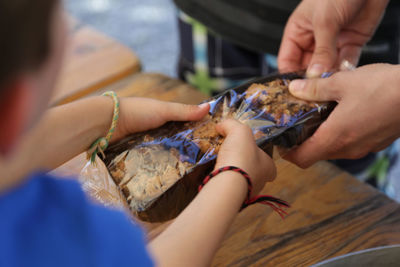 High angle view of person taking baked food from bakery