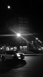 Cars on illuminated street at night