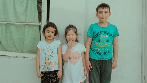 Portrait of friends standing against wall