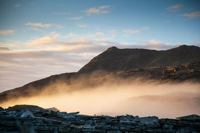 Mountains ape against sky with  highlited fog in the foreground