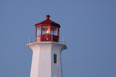 Low angle view of lighthouse against building against sky