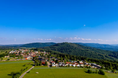 Panoramic view of landscape and buildings against blue sky