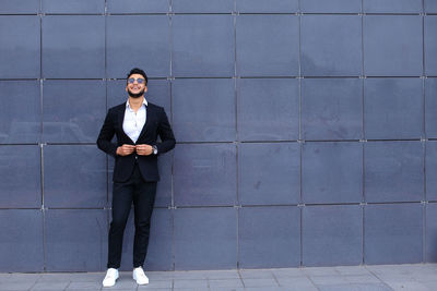 Full length of businessman standing against wall