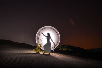 Rear view of woman standing at night