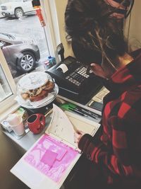 High angle view of woman reading book on table