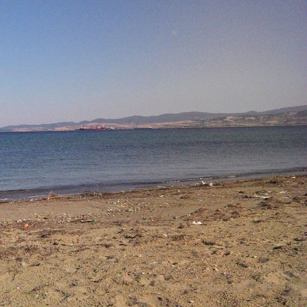 water, beach, sea, tranquil scene, clear sky, tranquility, shore, sand, scenics, copy space, beauty in nature, nature, blue, sky, idyllic, coastline, remote, day, outdoors, non-urban scene