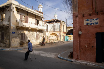 Rear view of man walking on street in city