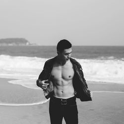 Man removing jacket at beach