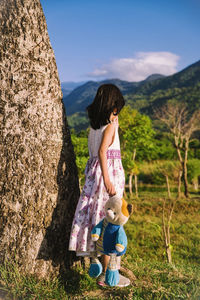 Woman standing on field against mountain