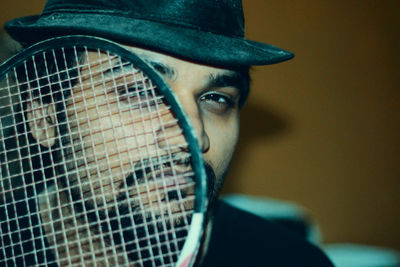 Close-up portrait of young man with badminton racket