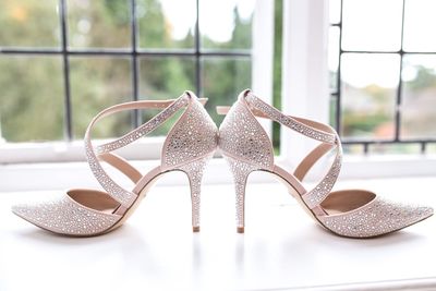 Close-up of shoes on table against window