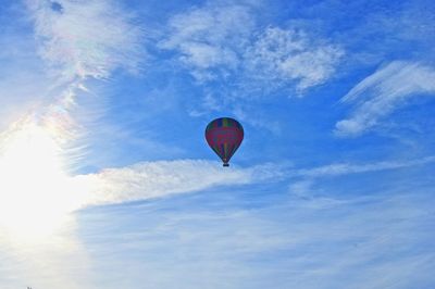 Low angle view of paragliding against blue sky