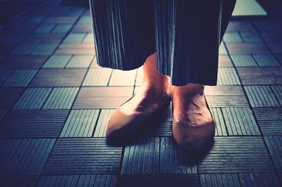 Low section of woman standing on tiled floor