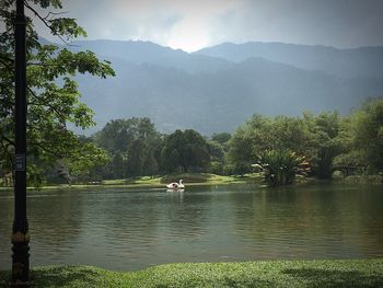 Scenic view of lake by trees against sky