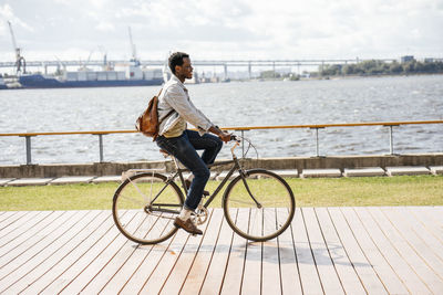 Young man riding bicycle at the sea