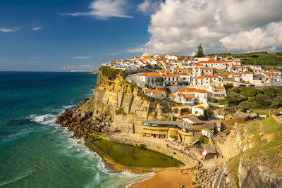 Panoramic view of sea and buildings against sky