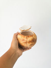 Person holding ice cream cone against white background