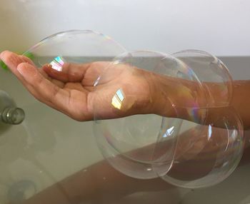 Close-up of hand holding bubbles in water