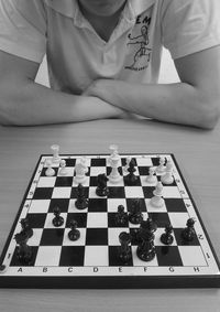 Midsection of man playing chess at table