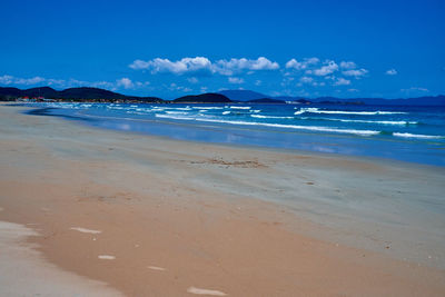 Scenic view of beach against blue sky