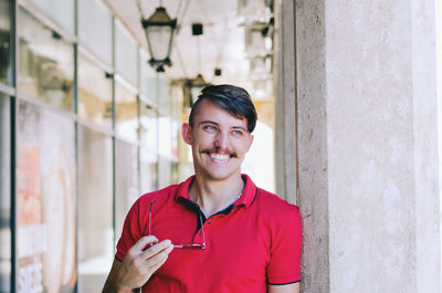 Young happy handsome bearded man, tourist, hipster walking in old city of koper. summer vacation