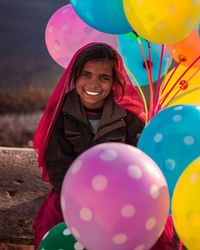 Portrait of smiling girl holding colorful balloons